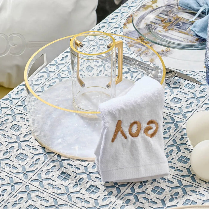 Pearlstone tall washing cup in white marble with gold accents displayed on decorative tablecloth with matching accessories