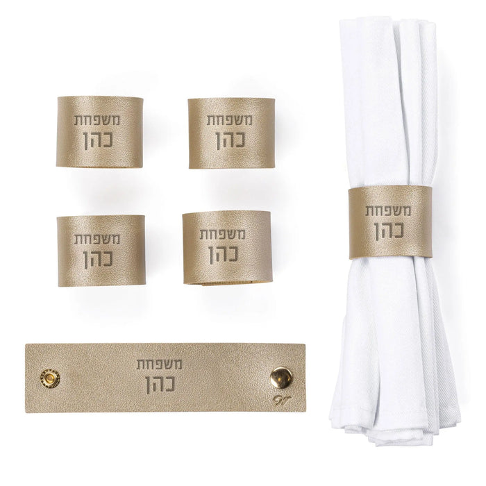 Waterdale Collection personalized leather napkin wraps in gold, displayed as a set of four rings with white napkins and matching place card holder.