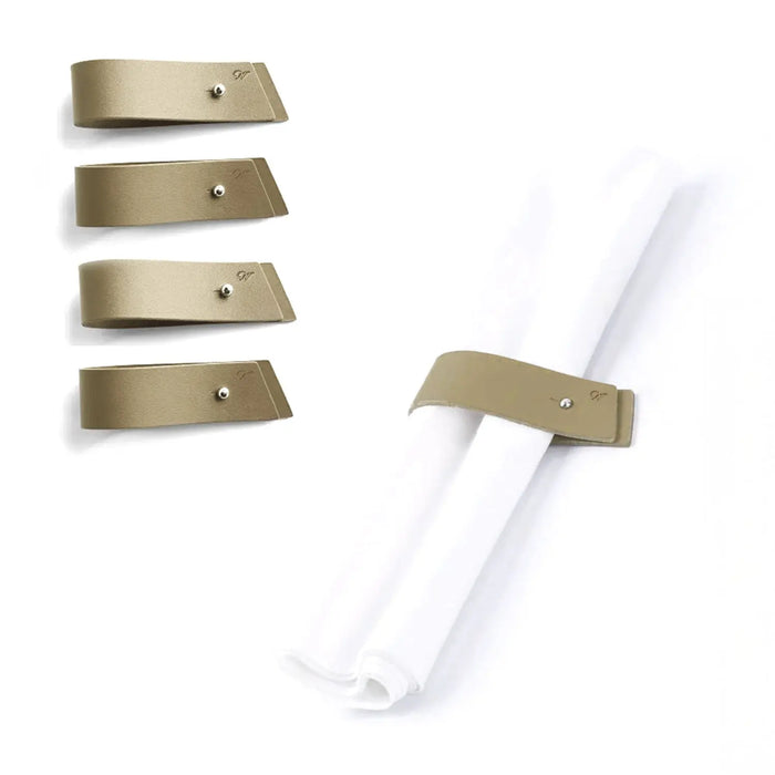 Gold and silver leatherette pin napkin wraps arranged in a group, showing the metal clasp detail and white napkin band for elegant table settings.