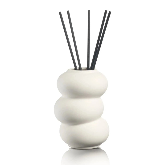 Stacked white ceramic donut-shaped reed diffuser with black rattan sticks by Waterdale Collection, modern home fragrance decor.
