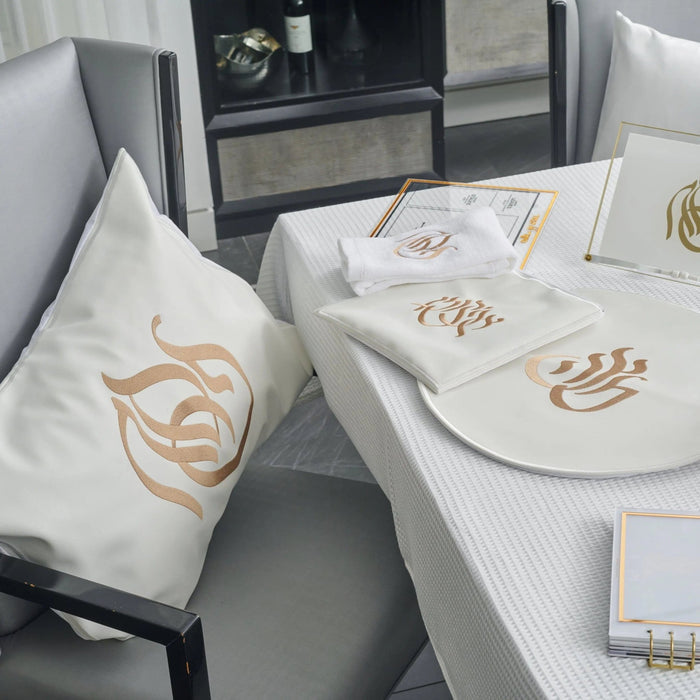 Regal Pesach Set in gold and white leather displayed on table with matching dinnerware and accessories for Passover holiday celebrations.