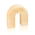 Cream-colored resin arch tzedakah box with embossed text, featuring a modern curved design for charitable giving and Jewish home decor.