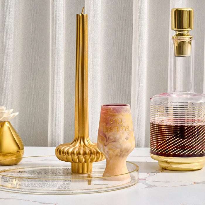 Resin Kiddush cup in blush and gold tones displayed with matching Havdalah set pieces and ceremonial items on marble surface.