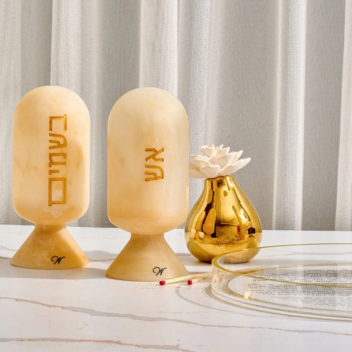 Wooden resin match cloche with carved Hebrew text, displayed with decorative gold bottle and glass, for Shabbat and havdalah use.