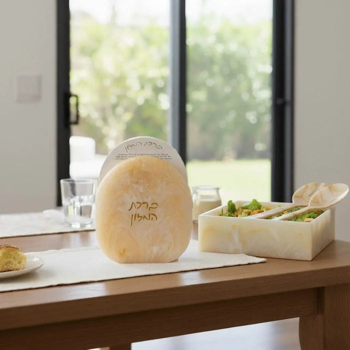 Gold glitter resin salad servers by Waterdale Collection displayed on a wooden countertop with tableware and greenery in background.