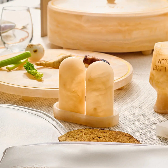 Amber resin salt shaker set with matching tray on wooden surface, featuring translucent honey-colored design ideal for table settings and entertaining.