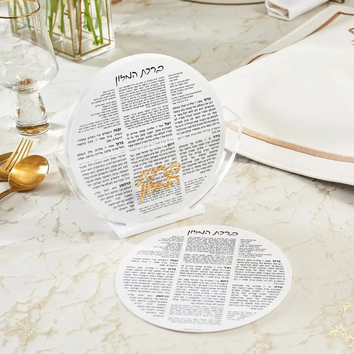 White round bencher set displayed on marble table with place settings and gold accents for Shabbat and holiday entertaining.