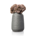 Rustic faux floral arrangement with dried-look brown flowers in a textured gray ceramic vase for tabletop decor.
