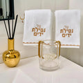Scalloped Netilas Yadayim Set with clear glass cup, gold pitcher, and two white towels with Hebrew text