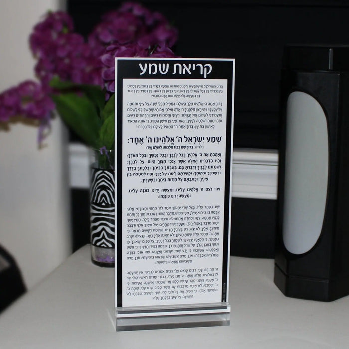 Waterdale Collection Shema Card in lucite with black and silver text on white background, displayed with purple flowers and home décor items