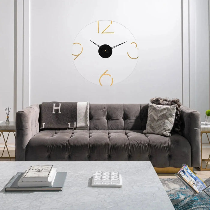 Gold Number Clock with black center and metal frame hanging above gray sofa in modern living room setting