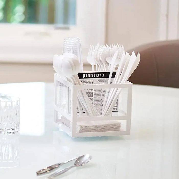 White acrylic silverware caddy organizer with utensil compartments and handle, displayed on white table with cutlery.