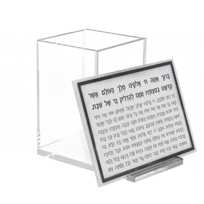 Single Shabbos candle holder with clear glass base and black metal frame, displayed with instruction card for Shabbat candle lighting.