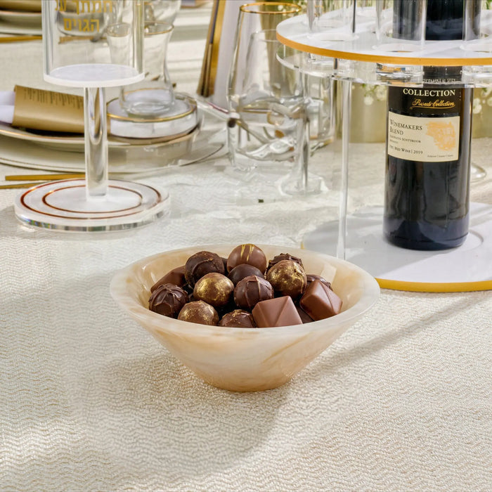 Cream resin round bowl filled with mixed nuts, styled on a white tablecloth with wine glasses and place settings in background.