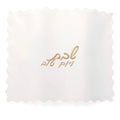 Gold leather challah cover with delicate scalloped edges and Hebrew text embroidered on white fabric insert