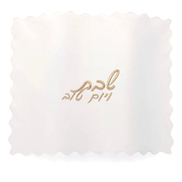 Gold leather challah cover with delicate scalloped edges and Hebrew text embroidered on white fabric insert