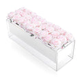 Soft pink faux roses arranged in a clear rectangular acrylic box, elegant tabletop floral centerpiece by Waterdale Collection.