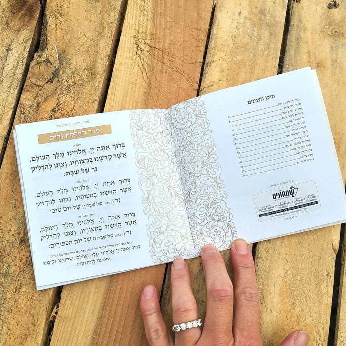 Cream and gold leather softcover bencher set displayed open on wooden surface, showing printed pages and binding details for Birchat Hamazon.