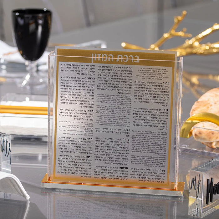 Square Bencher Set in black and gold by Waterdale Collection, displayed on table with Shabbat settings and decorative lighting.