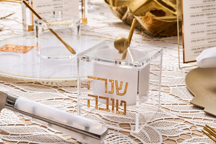 Suspended Lucite Shana Tova honey dish with a gold spoon for the Jewish New Year