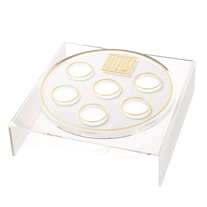 Tall suspended seder plate with clear lucite construction featuring six circular wells and gold-tone accents for Passover.