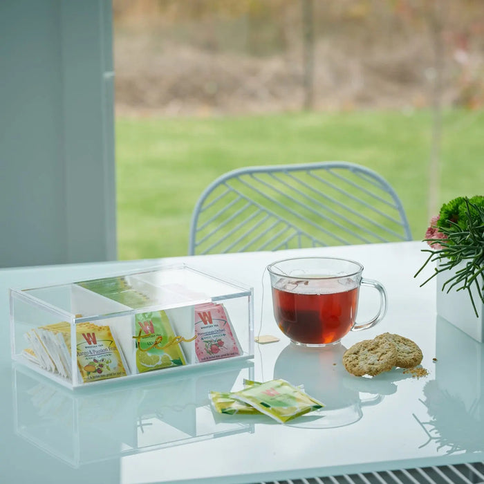 Waterdale Collection silverware tea caddy with clear glass compartments displaying tea bags and accessories on white table near window
