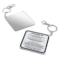 Tefillin mirror keychain with silver-toned square reflective surface and attached instruction card, displayed with two metal key rings.