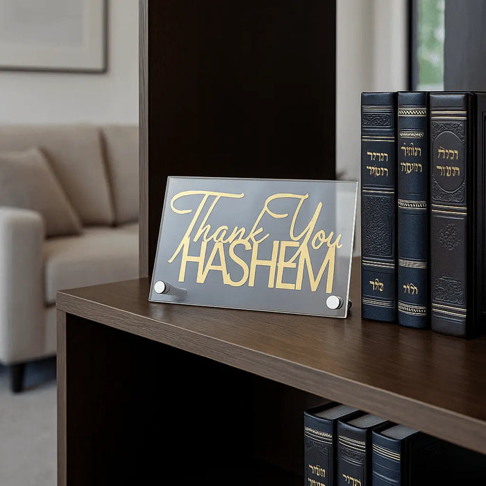 Thank You Hashem gold tabletop plaque displayed on wooden shelf with books and home decor