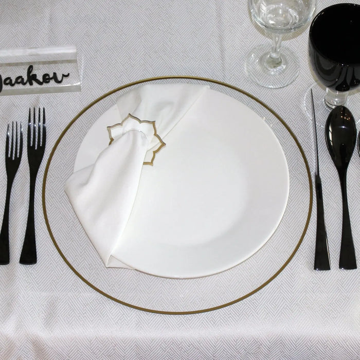Thin Border Charger plate with silver rim on white tablecloth, place setting with black flatware and glassware from Waterdale Collection.