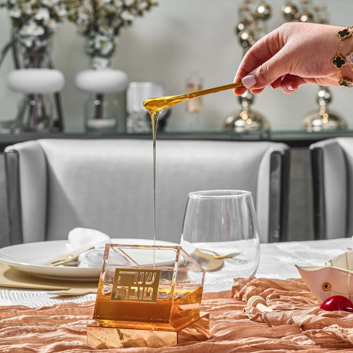 Gold Tilt honey dish styled on a Jewish New Year table setting