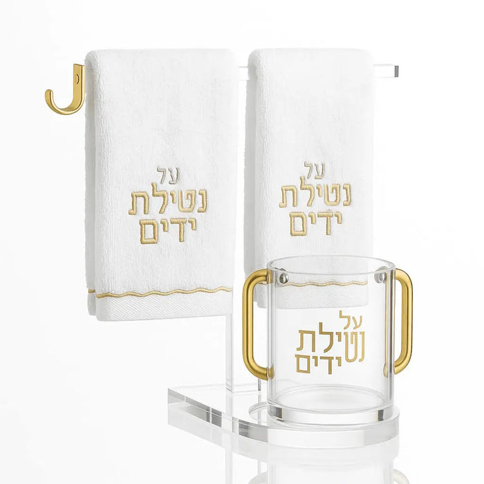 White towel and cup stand with gold accents and Hebrew text, featuring a ring holder for bathroom or vanity display.