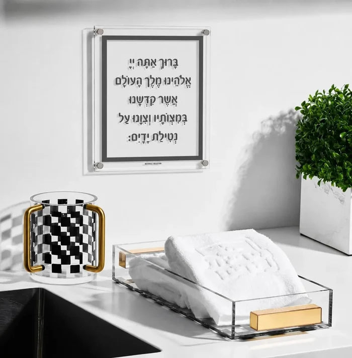 Traditional Al Netilas Yadayim acrylic plaque displayed above a bathroom sink alongside an Onyx checkered washing cup and acrylic guest towel holder — Waterdale Collection