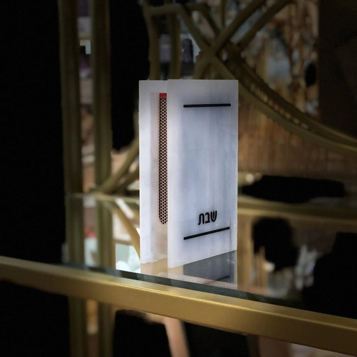 Traditional marble matchbox holder with silver shimmer finish, displayed on a shelf with home decor items in background
