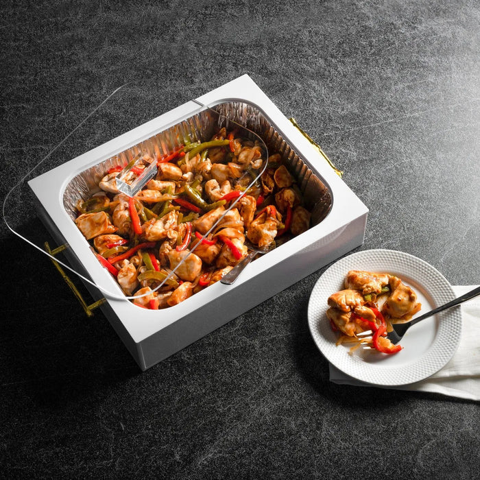 White rectangular Twig 9x13 pan holder displaying a colorful baked dish with serving spoon on dark surface.