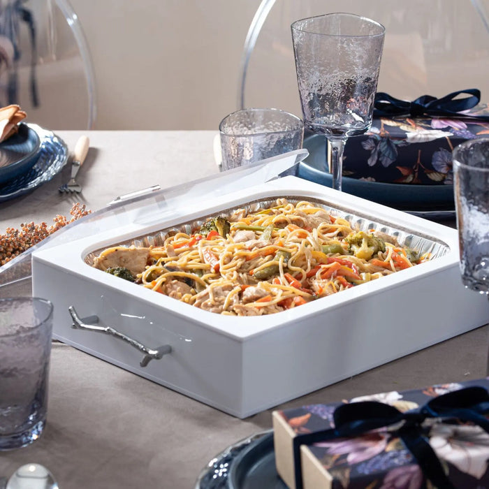 White Twig 9x13 pan holder displaying a baked casserole on a dining table with place settings and glassware nearby.