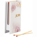 Watercolor matchbox holder with pink floral design and gold accents, displayed with wooden matches