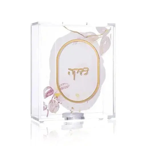 Watercolor Tzedakah Box with hand-painted oval design in soft beige and purple tones, displayed in clear packaging with decorative bow.