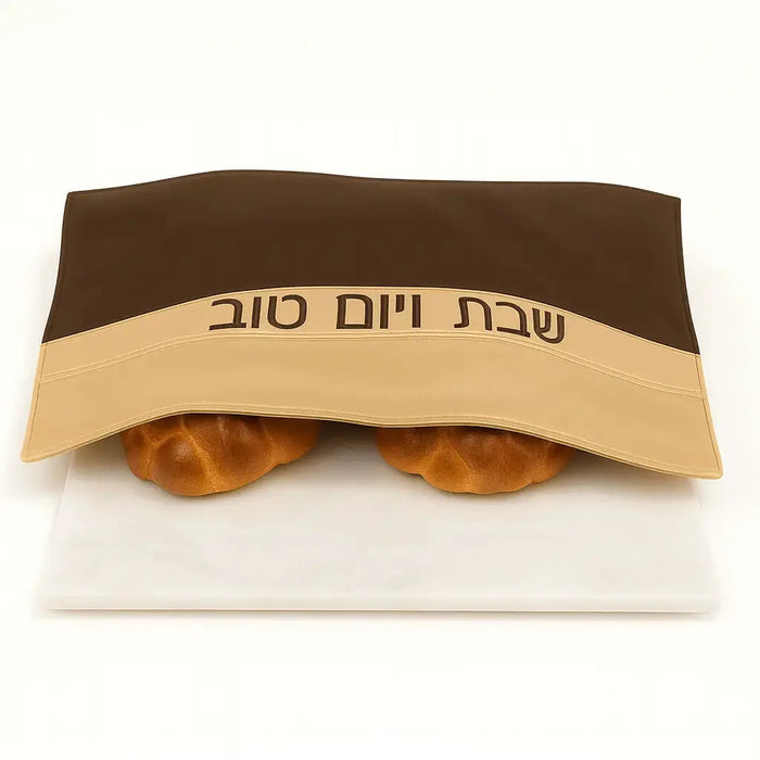 Waterdale wood challah board with matching fabric cover featuring Hebrew text, displayed with two braided loaves on white surface.