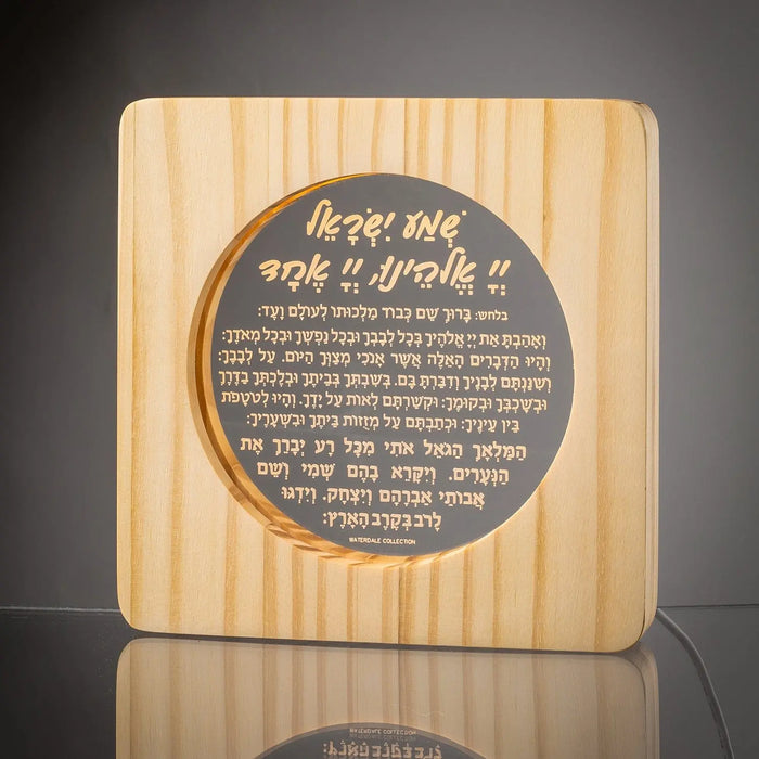 Wood Shema lamp with natural striped finish and circular dark metal plaque featuring Hebrew text, perfect for a child's room or nursery.