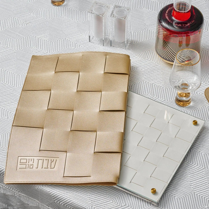 Woven challah board and cover set in natural tan with wooden square tiles, displayed with Shabbat candles and wine glasses on white surface.