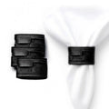 Black woven leather napkin wraps displayed on white napkins, showing textured woven design for elegant table settings