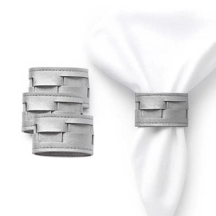 Silver woven leather napkin rings from Waterdale Collection, displayed on white napkins for table setting.